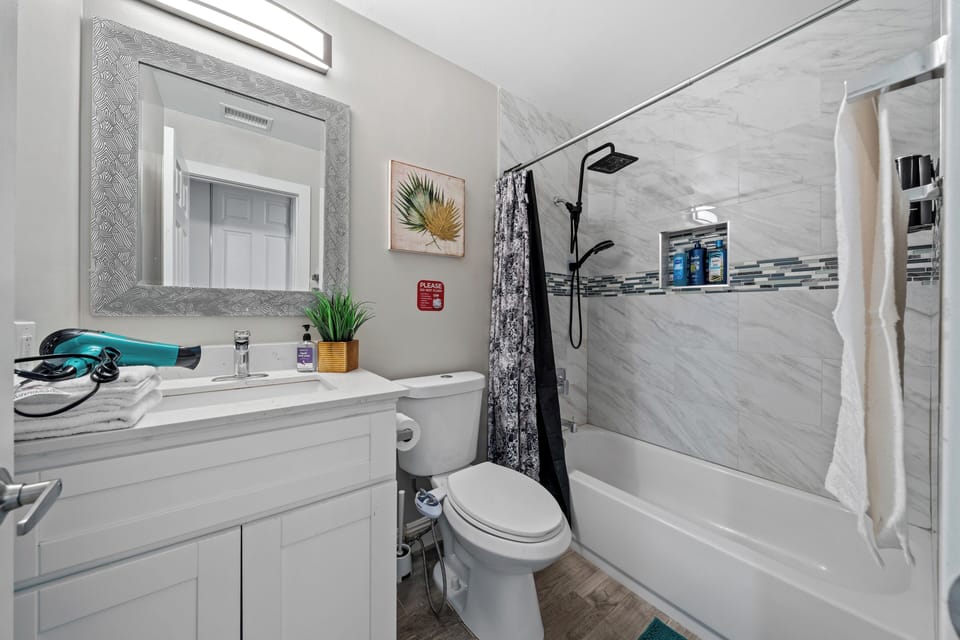 Enjoy a fully equipped bathroom with a bathtub and handy hair dryer.