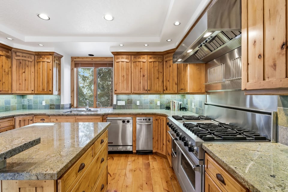 Gourmet kitchen with stainless steel appliances, granite countertops, and natural wood cabinetry, designed for luxury cooking.