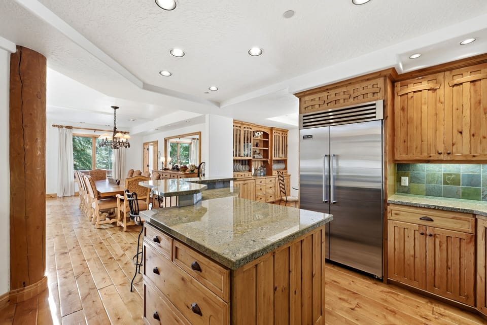 Spacious kitchen with center island, stainless steel appliances, and warm wood cabinetry, seamlessly connected to the dining area.