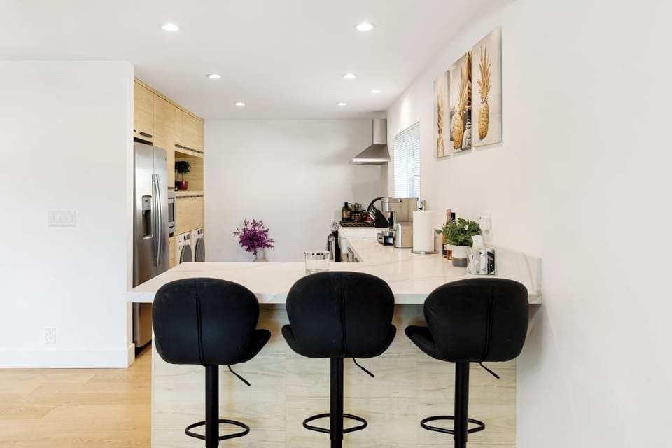 Modern kitchen with breakfast bar and light wood cabinetry.