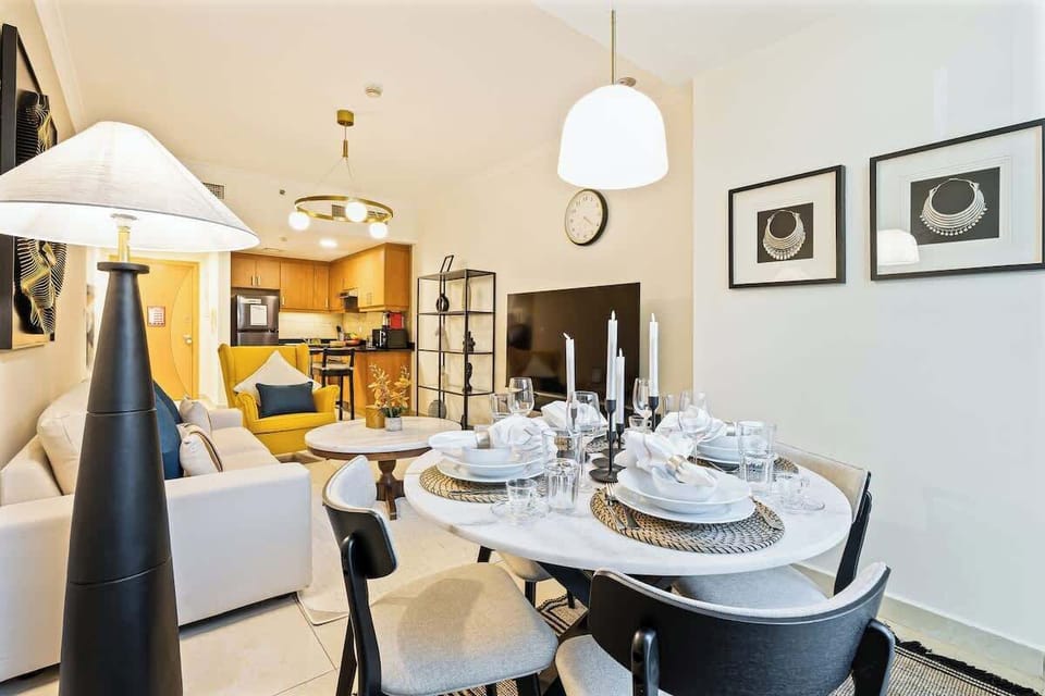 Cozy dining area featuring a comfortable four-seater table next to a large window with stunning lake views, seamlessly connected to the living area for a spacious and inviting layout.
