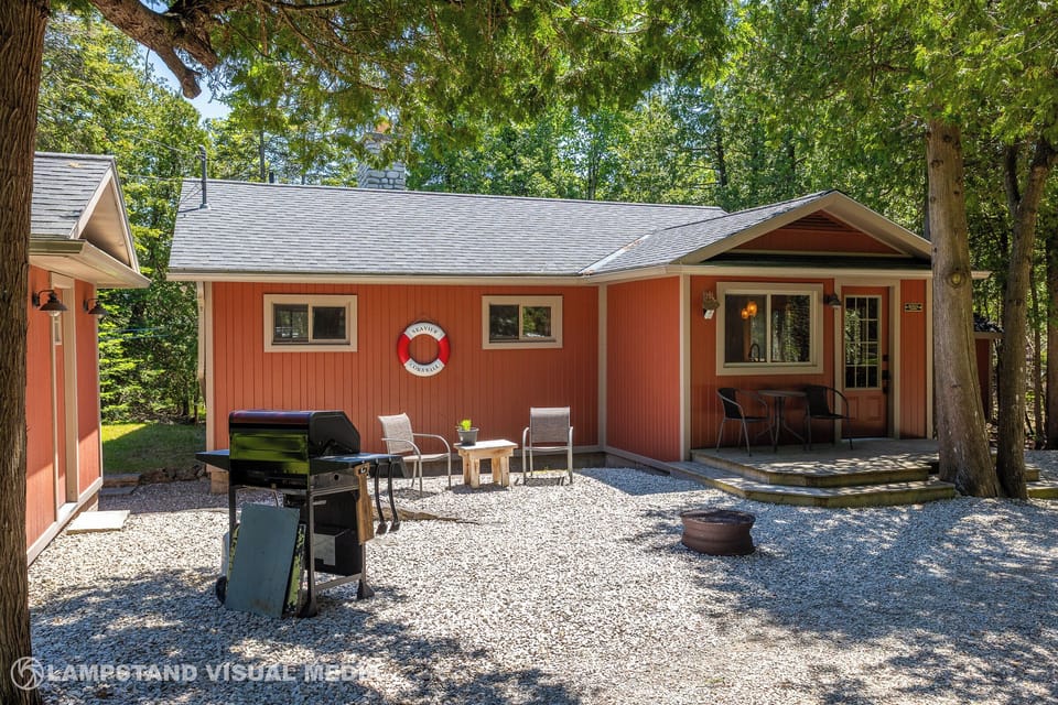 Front view of the cottage with plenty of space to unwind outdoors, complete with BBQ and seating.