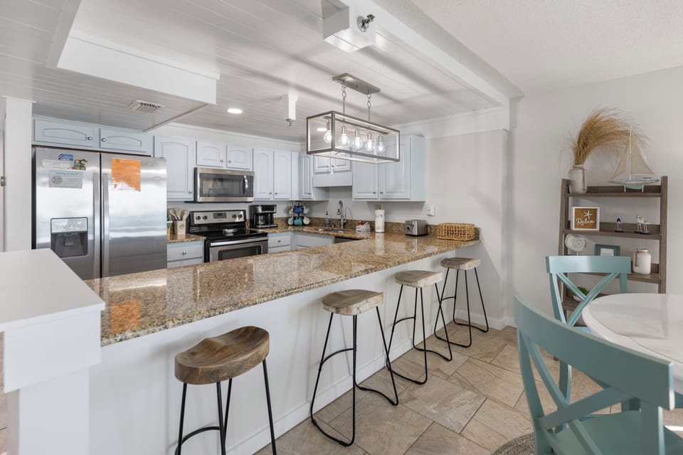 Your spacious kitchen features granite counters, stainless appliances, and a breakfast bar where you can gather for morning coffee or casual meals.