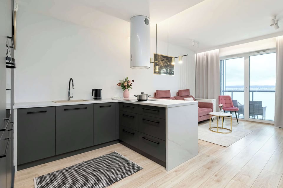 Streamlined kitchenette with graphite cabinetry, built-in appliances, and a minimalist finish.