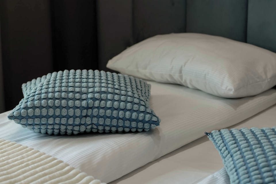 Comfort-focused sleeping area with patterned cushions and layered bedding.