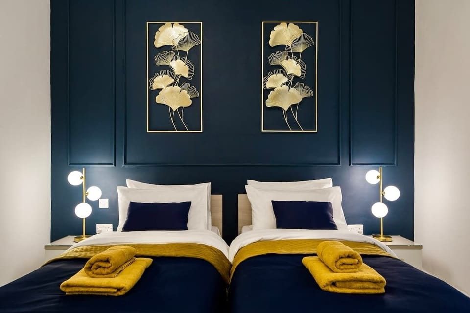 The second bedroom offers flexible twin beds, elegant wall art, and soft lighting to create a calm and inviting atmosphere.