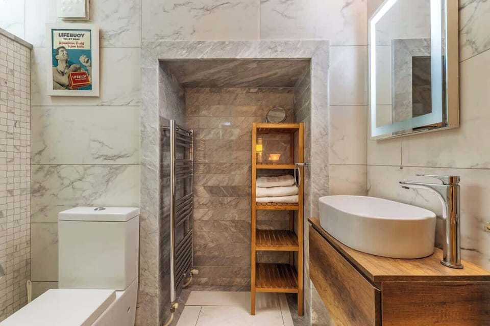 The Pinto Suite's en-suite bathroom is thoughtfully designed with a high-pressure rainfall shower and heated towel rail, ensuring that your stay in Valletta is as comfortable and rejuvenating as possible.