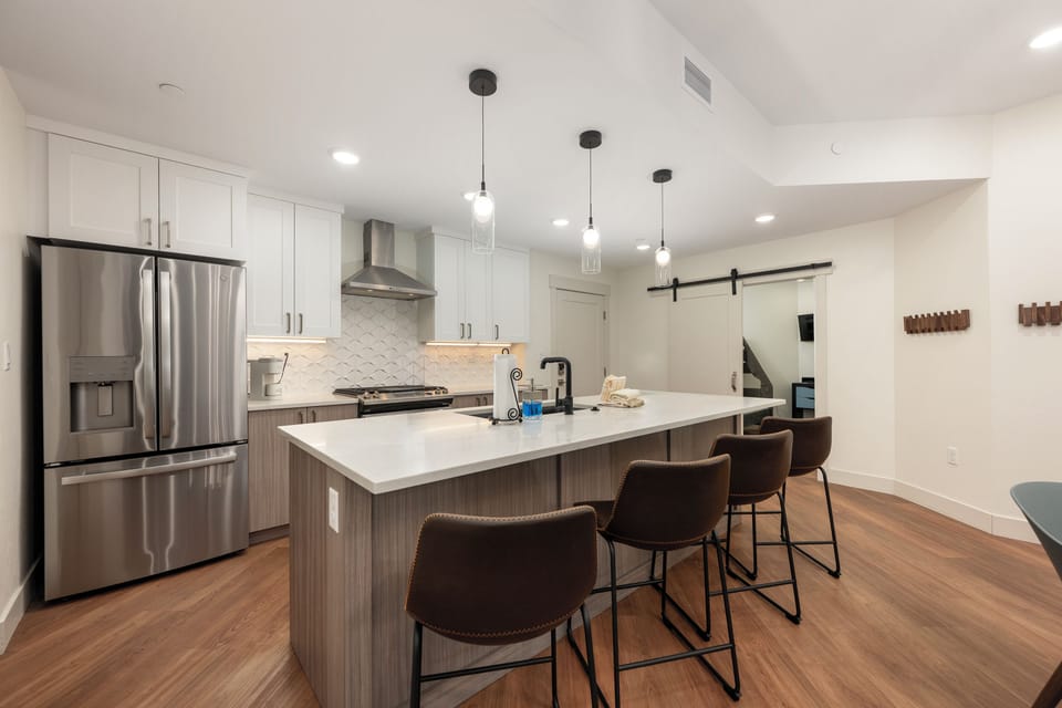 Your sleek kitchen awaits with modern appliances and a spacious island perfect for morning coffee or evening conversations with friends.