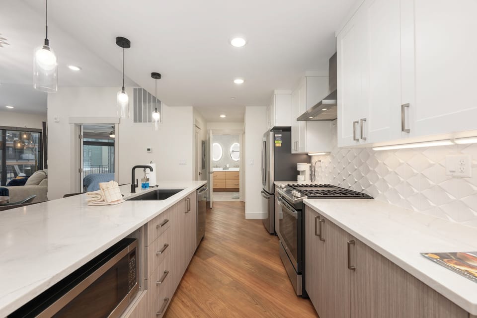 Your sleek gourmet kitchen awaits with granite counters, stainless appliances, and modern pendant lighting for memorable cooking experiences.