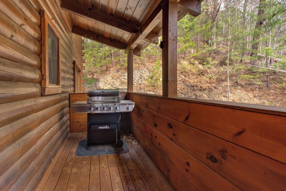 Your private covered deck with gas grill overlooks peaceful woodland, perfect for morning coffee or evening barbecues surrounded by nature.