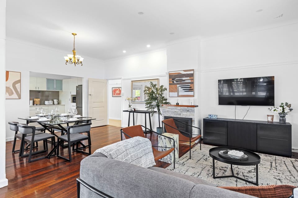 Relax in this stylish, open-plan living and dining area with beautiful hardwood floors and a modern fireplace. Book your unforgettable stay today!