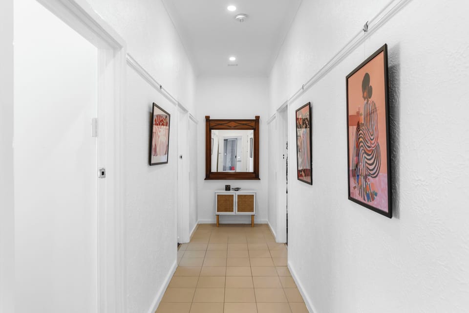 Bright, inviting hallway with unique artwork leading you to rest and relaxation. A warm welcome awaits.