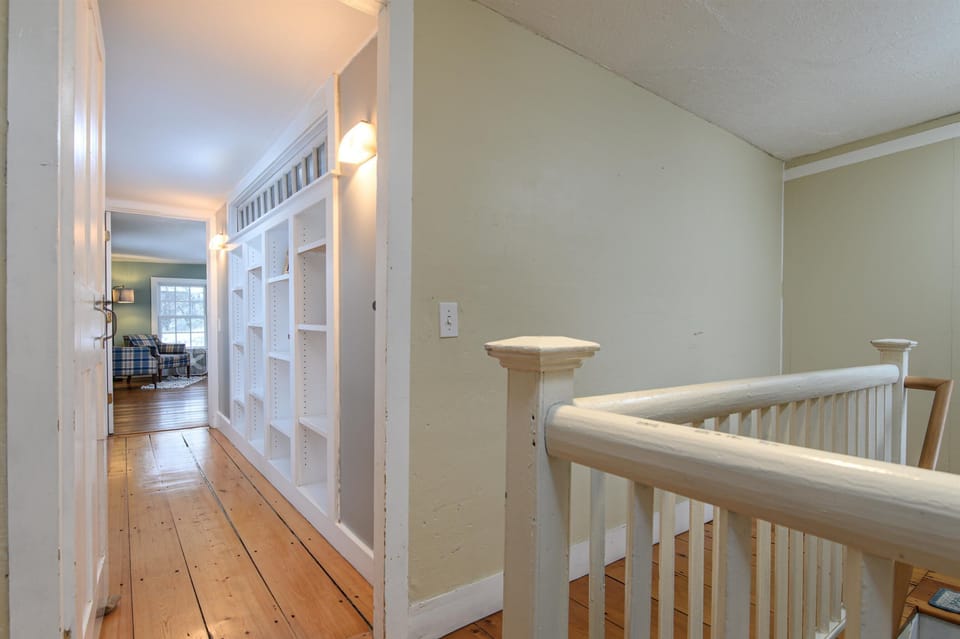 Your bright hallway features beautiful hardwood floors and built-in storage shelving, creating an organized and welcoming space as you move through your home.