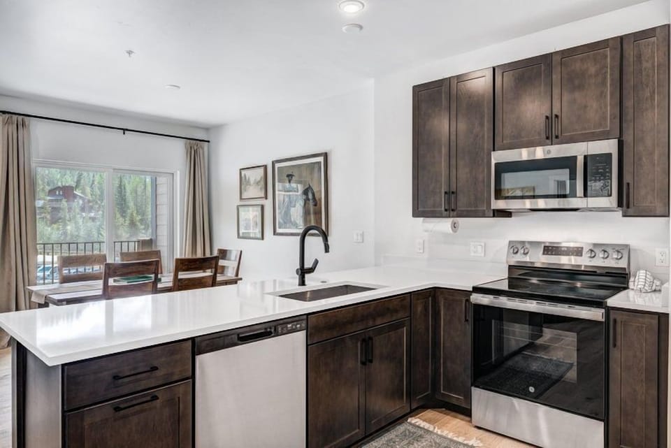 This beautifully designed kitchen connects seamlessly to the dining area, enhanced by natural light from large windows overlooking stunning mountain views.