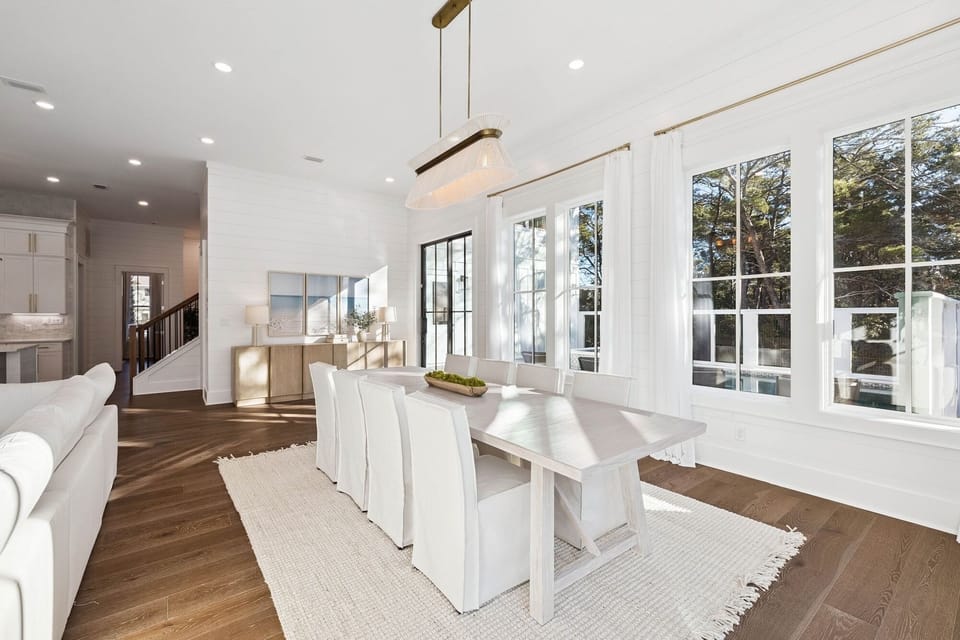 Gather around this elegant dining table bathed in natural light, where memorable meals await in your sophisticated retreat.