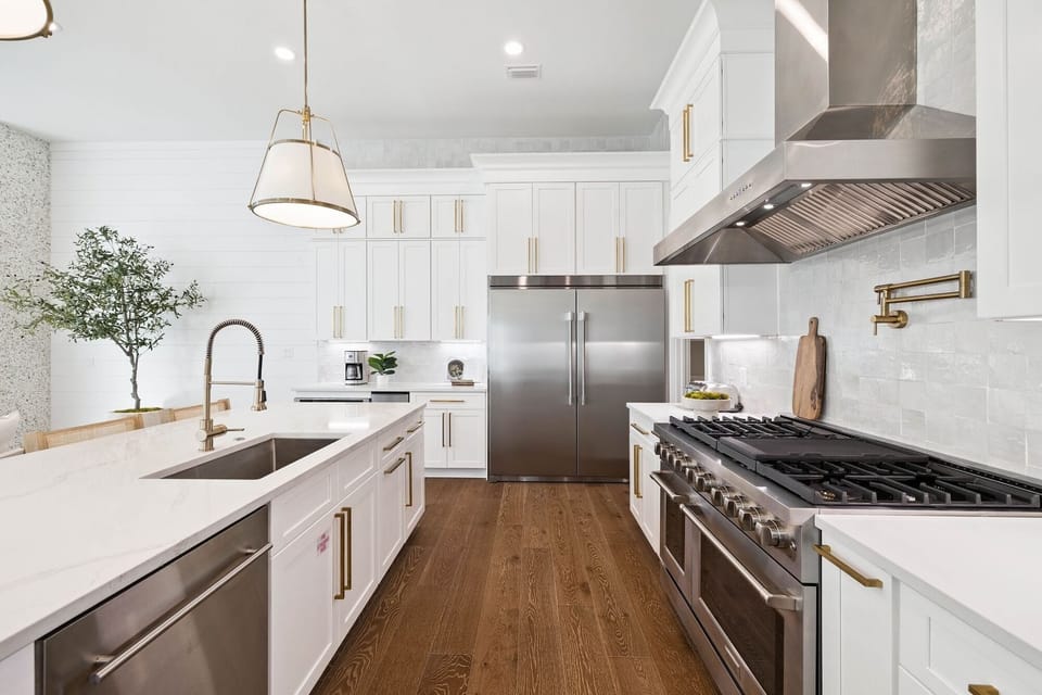 Your sleek chef's kitchen awaits with professional-grade appliances, gleaming countertops, and elegant gold accents to inspire culinary adventures.