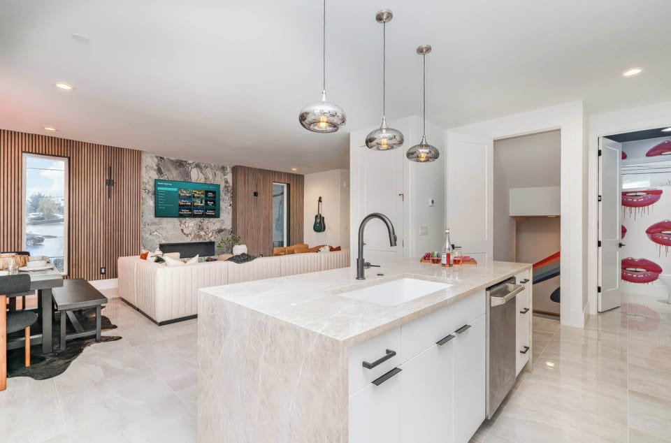 Open kitchen flows straight into the living room, so the cook stays part of the party while the group spreads across the sectional and bar stools in Nashville