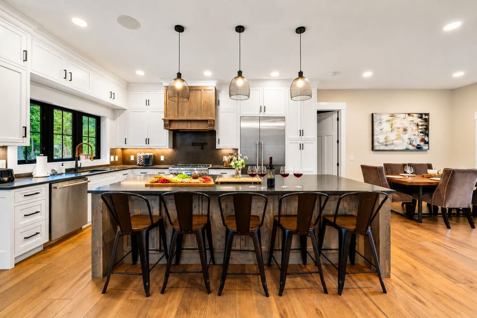 Bright designer kitchen with large island, bar seating, and dining area