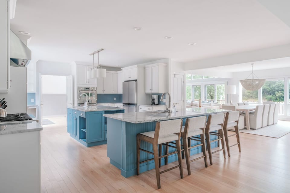 Modern chef’s kitchen with island seating, stainless appliances & full cookware.