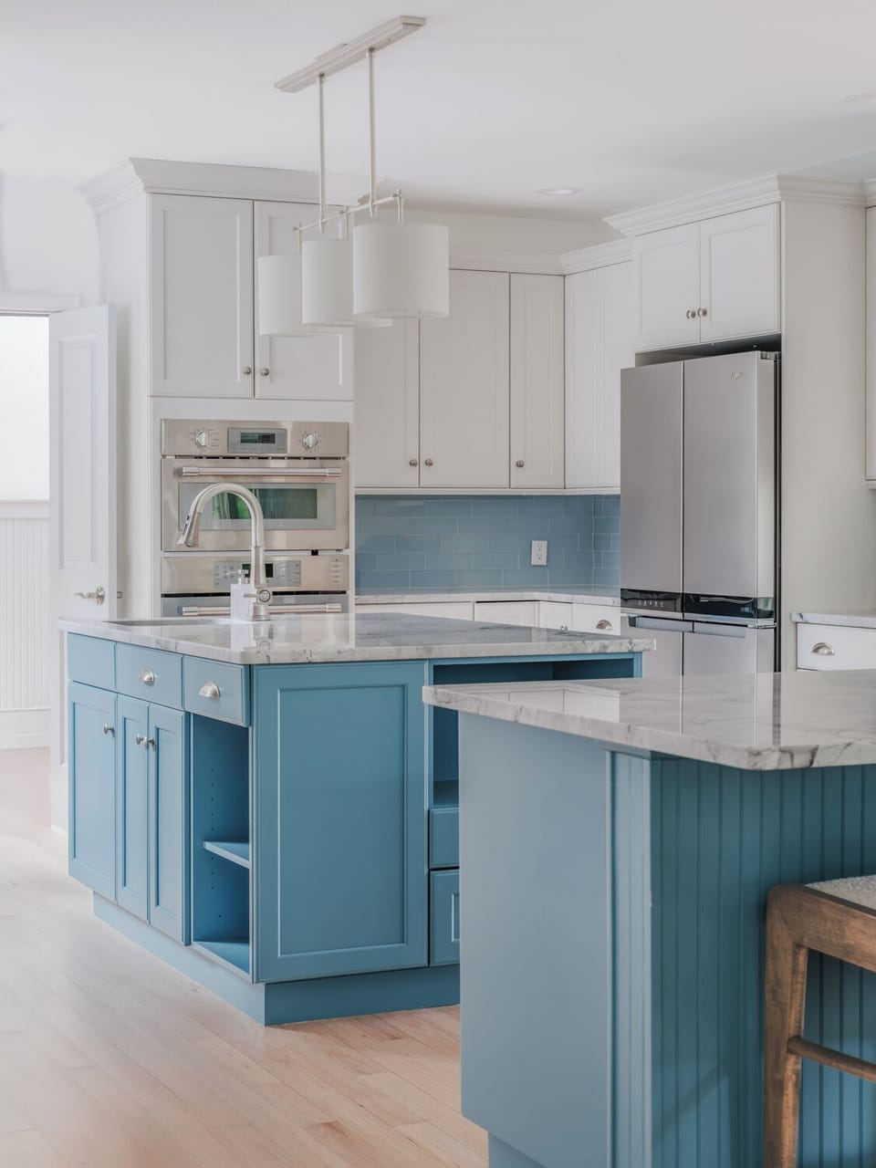 Modern chef’s kitchen with island seating, stainless appliances & full cookware.