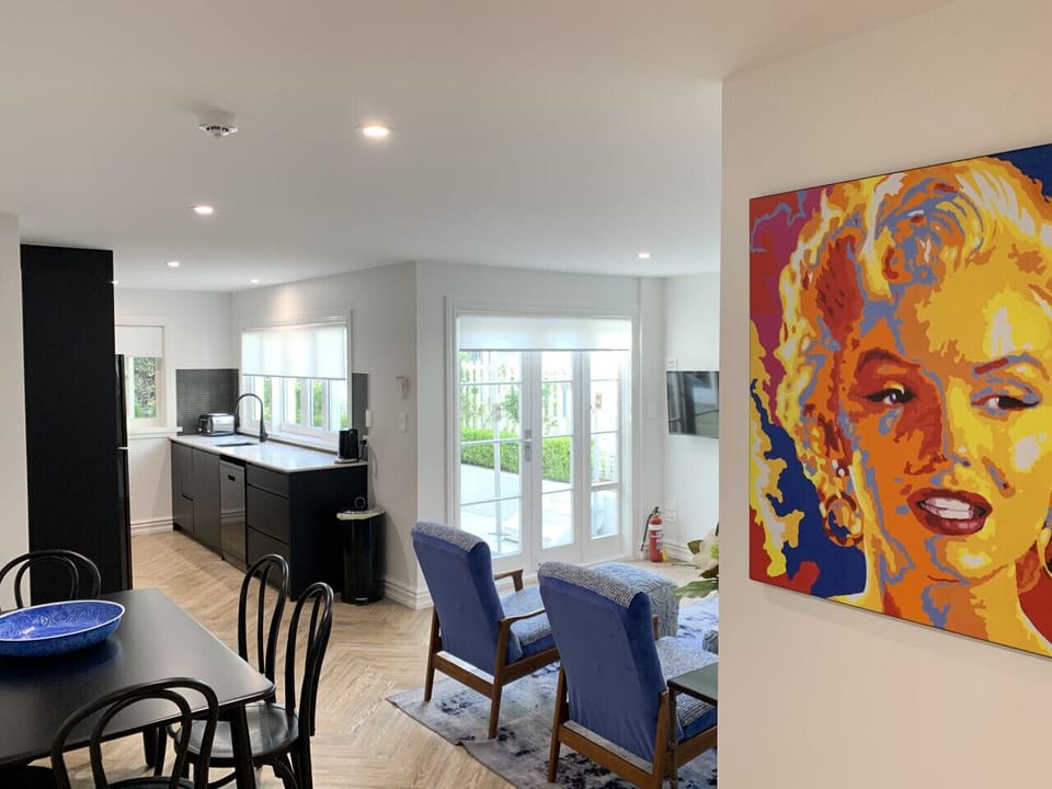 Gorgeous open plan living room with herringbone wooden flooring, smart TV, cosy couches and complete with air conditioning