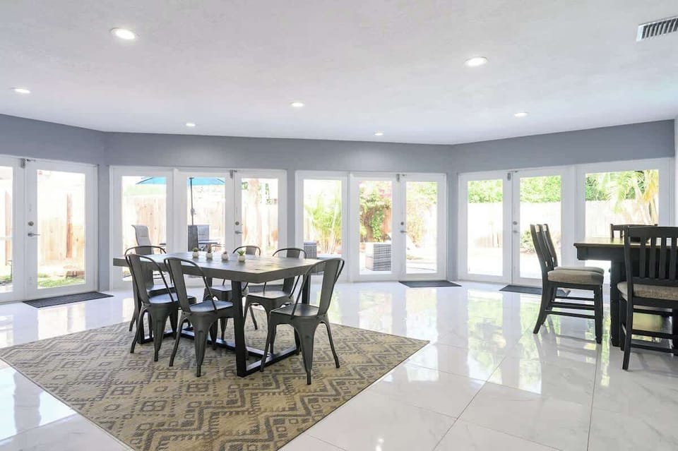 "Bright, spacious dining with two tables—perfect for family meals, remote work, or group getaways. Enjoy natural light, modern design, and easy flow to outdoor living in your vacation rental!"
