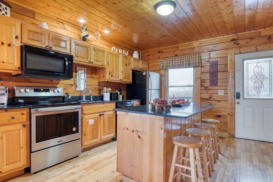 Kitchen with barstool seating and stainless steel appliances.