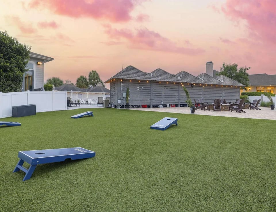 Outdoor lawn with cornhole games and evening lights