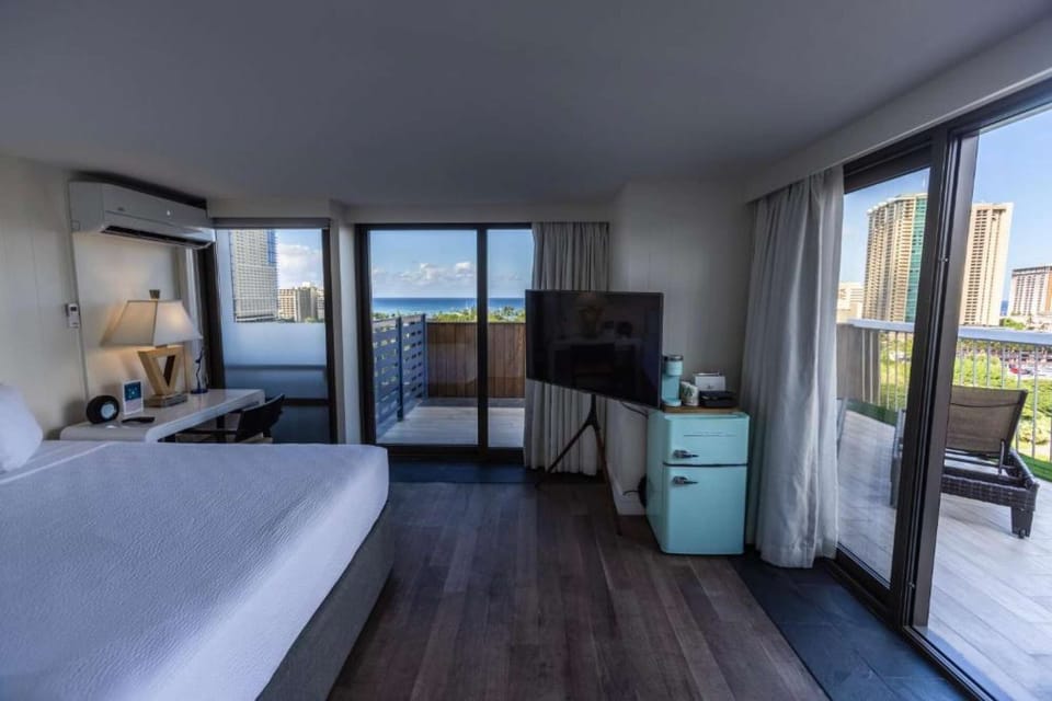 Room with wide windows and a terrace facing city and ocean