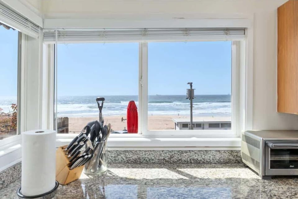 Sunlight pours into the kitchen with sweeping ocean views, turning everyday moments into something quietly special.