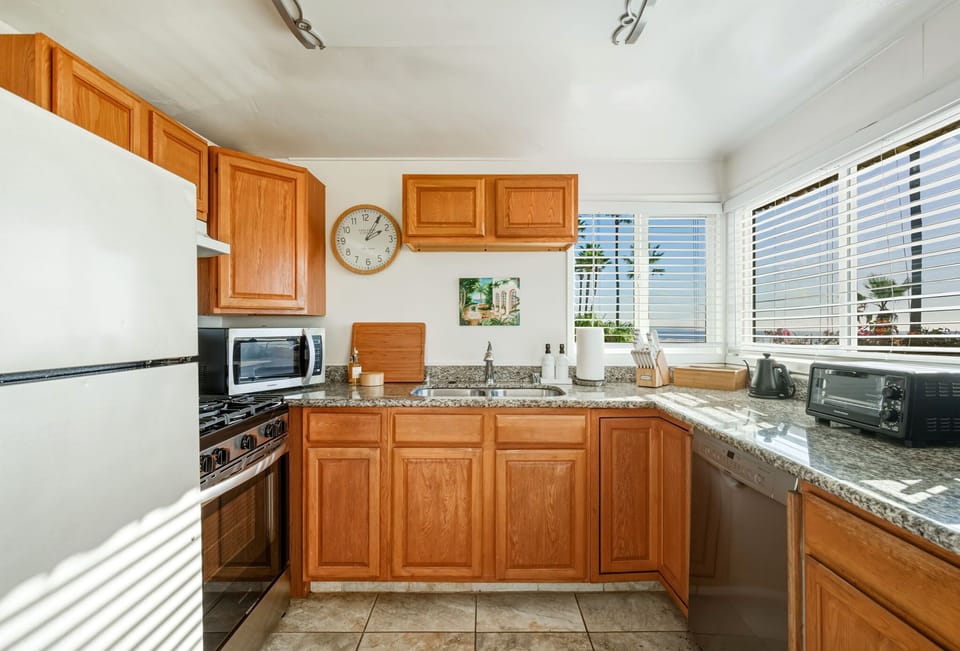 A well-appointed kitchen filled with natural light, offering ocean glimpses and everything needed for easy, comfortable meals at home.