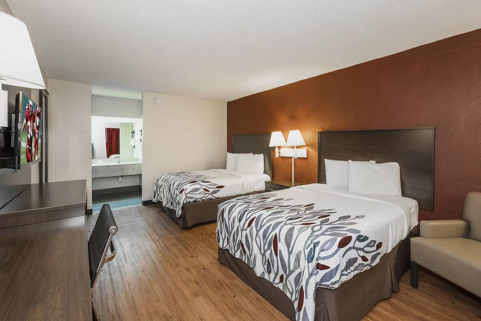 Unwind in a spacious double-queen room with warm lighting.