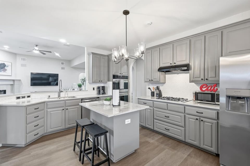 Undeniably the heart of the home with high-end appliances, a kitchen island, and beautiful countertops, this fully equipped kitchen is a dream to cook in!