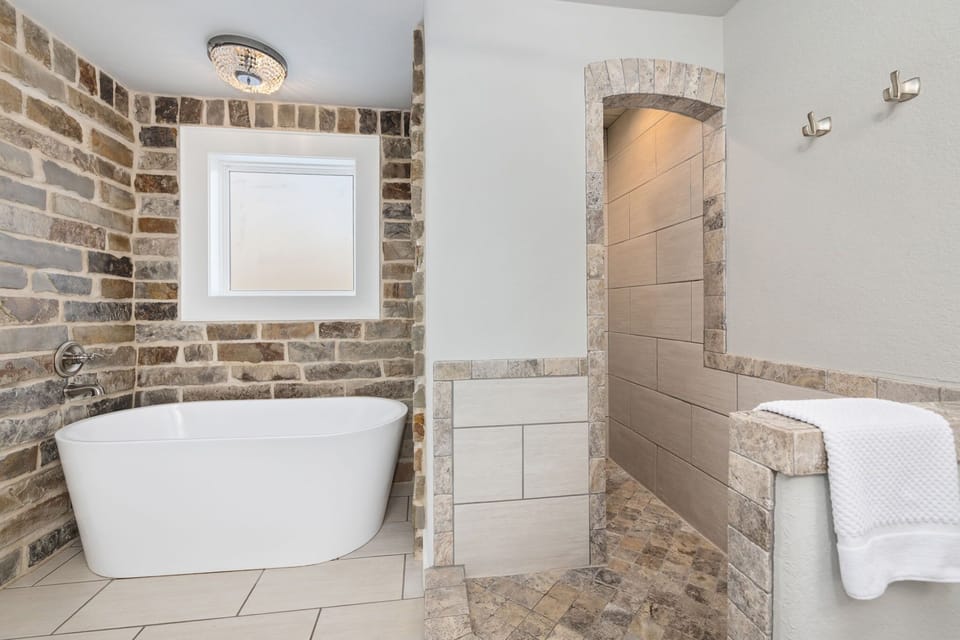 The full bathroom in the primary bedroom. Features a Walk-In Shower and separate Tub