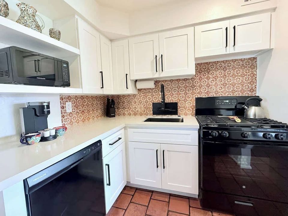 Newly updated kitchen: sleek black appliances, new cabinets, dishwasher, and Keurig. We preserved the Southwestern charm with authentic Saltillo tile floors and vibrant Talavera tile backsplash!