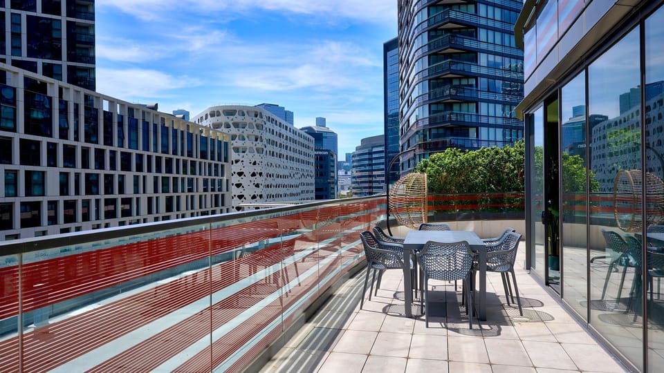 Expansive private balcony with outdoor seating and stunning city views.