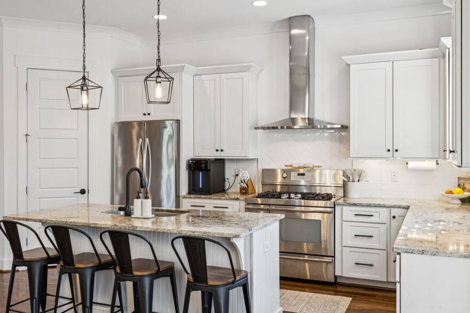 Fully-equipped, modern kitchen with stainless steel appliances,  stone countertops, a 5 burner gas stove with double ovens and a walk-in pantry! Seating for 4 at the kitchen island.