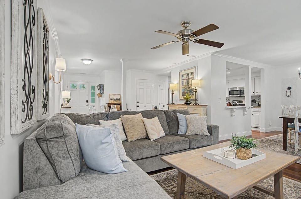 Settle into this inviting living space where soft gray sectionals and warm wood accents create your perfect retreat for relaxation.