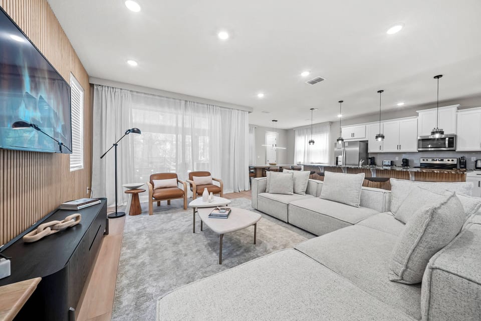 Unwind in the warm natural light of this inviting living area, complete with a cozy gray sectional and elegant wood accents. Enjoy the soft textures and modern decor that create a tranquil atmosphere, perfect for effortless.