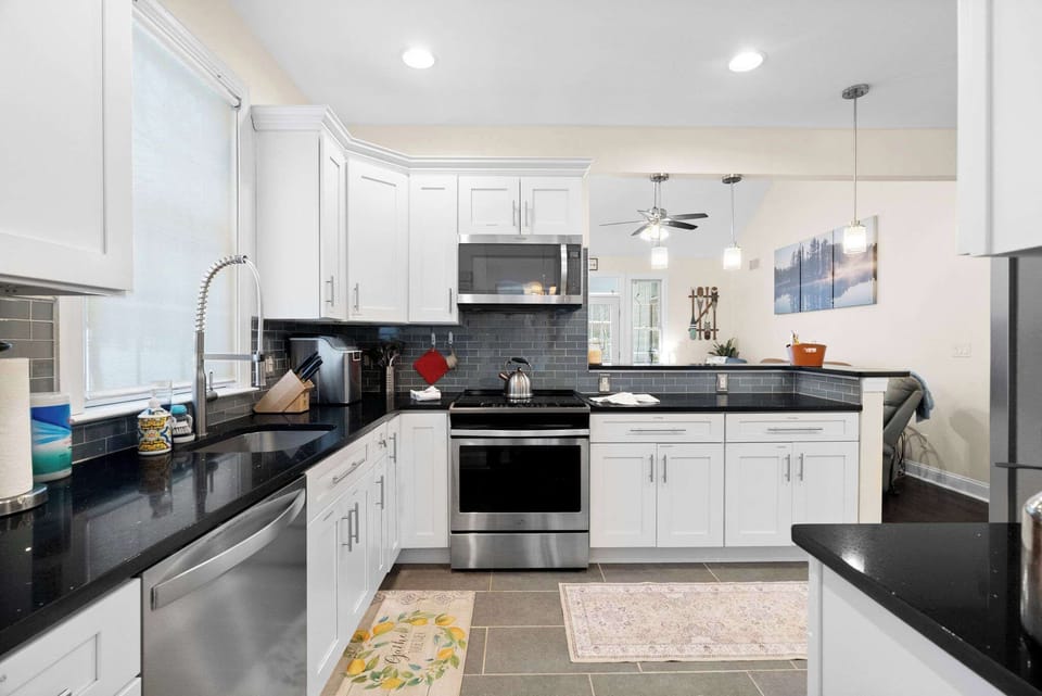 Modern fully-equipped kitchen with stainless steel appliances, breakfast bar and ample seating for groups