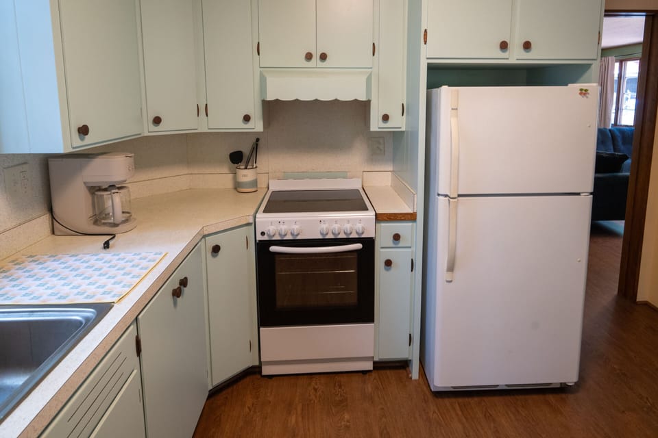 Kitchen with fridge, stove, oven, coffee maker and other essentials