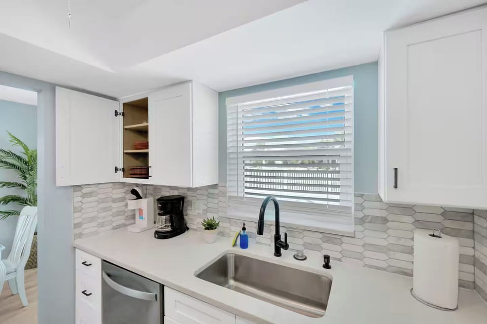 The kitchen is stocked with a microwave, toaster, blender, and tea kettle.