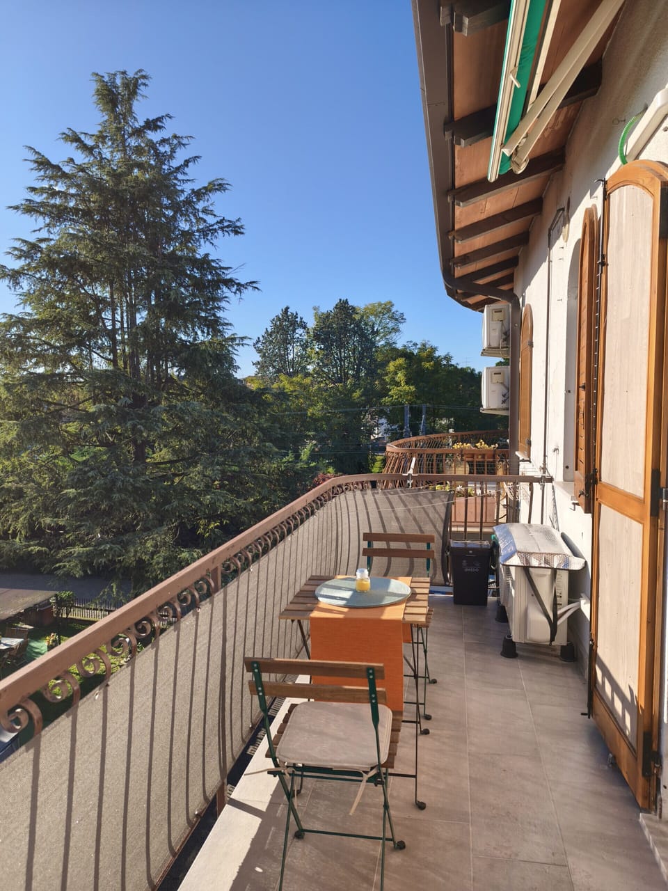 Private balcony of the apartment in Peschiera del Garda, furnished with table and chairs for relaxing outdoors. Ideal for enjoying breakfast or an aperitif with a view of the greenery in a quiet residential area.