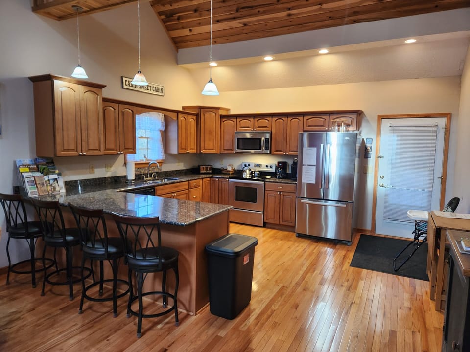 Dining area & kitchen w/ granite counters and stainless steel appliances.