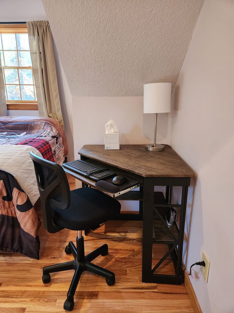 Corner work station with desk chair, keyboard, and mouse provided.