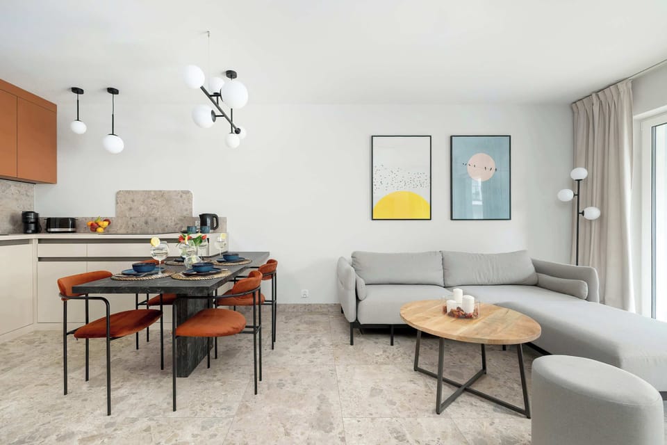 Minimalist living room with a compact dining nook and neutral color palette.