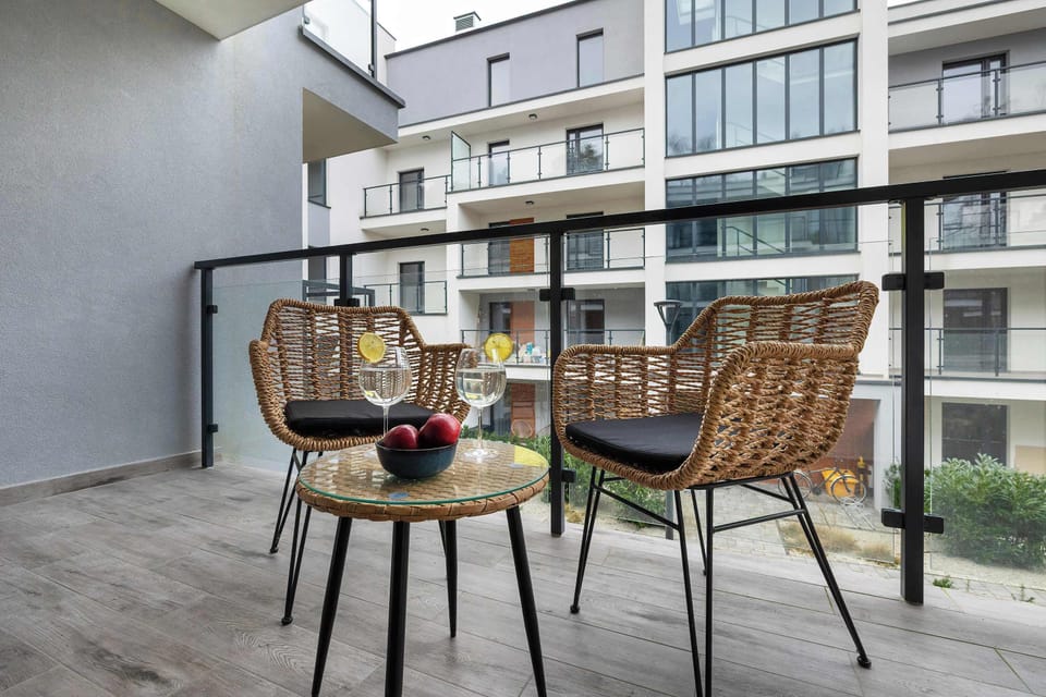 Inviting balcony with comfortable seating and views of a contemporary building.