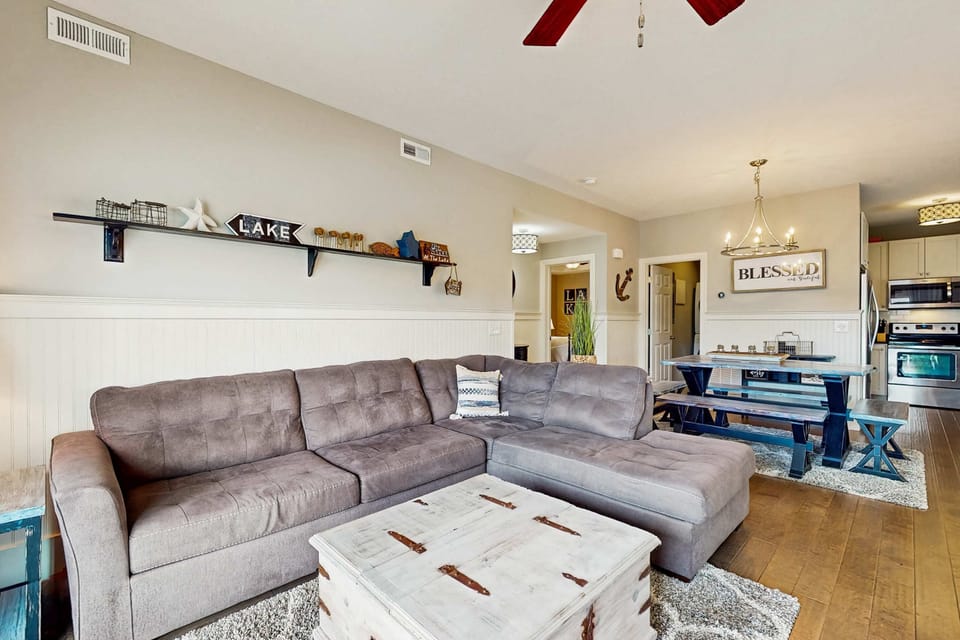 Comfortable living room with large sectional sofa, coffee table, and open layout leading to the dining area.