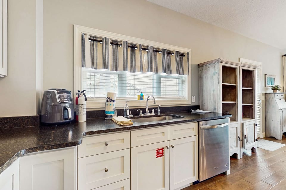 Kitchen counter space with sink, dishwasher, small appliances, and storage cabinets.