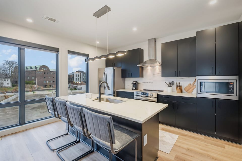 Sleek, modern kitchen with large island for dining and easy access to the living area.